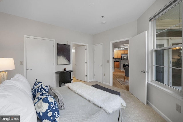 bedroom with baseboards and light colored carpet