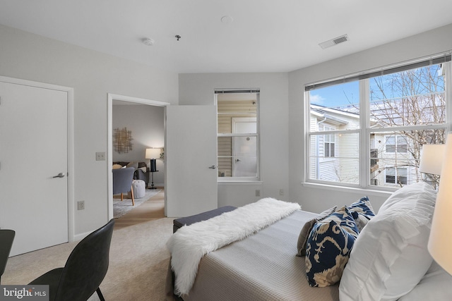 bedroom with light carpet and visible vents