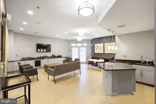 living room featuring light wood-style floors, visible vents, and recessed lighting