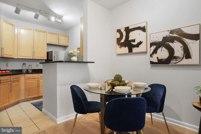 dining room featuring baseboards and light tile patterned flooring