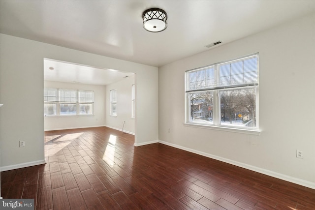 unfurnished living room featuring dark hardwood / wood-style flooring and plenty of natural light