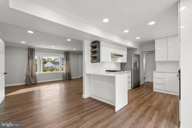 kitchen featuring backsplash, dark hardwood / wood-style floors, kitchen peninsula, and white cabinets