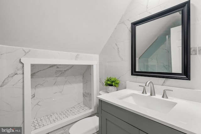 bathroom with toilet, a shower, vaulted ceiling, tile walls, and vanity