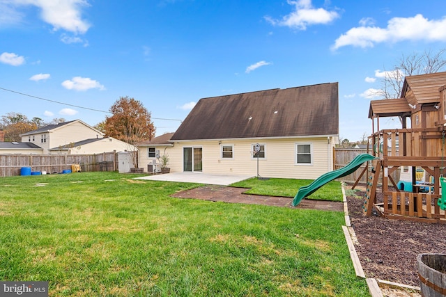 rear view of house with a yard, a playground, and a patio area