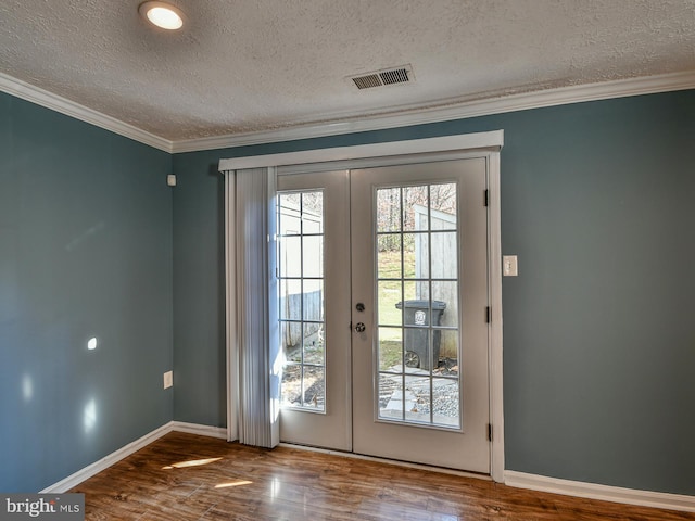 doorway with crown molding, hardwood / wood-style floors, a textured ceiling, and french doors