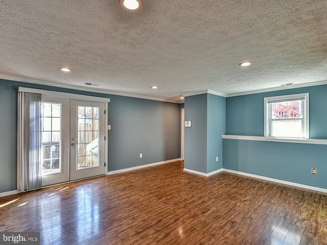 spare room featuring french doors, a healthy amount of sunlight, wood-type flooring, and a textured ceiling