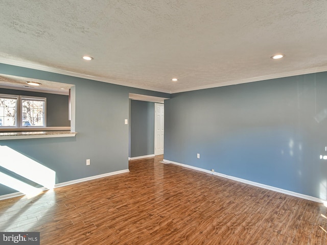 unfurnished room with hardwood / wood-style floors, ornamental molding, and a textured ceiling