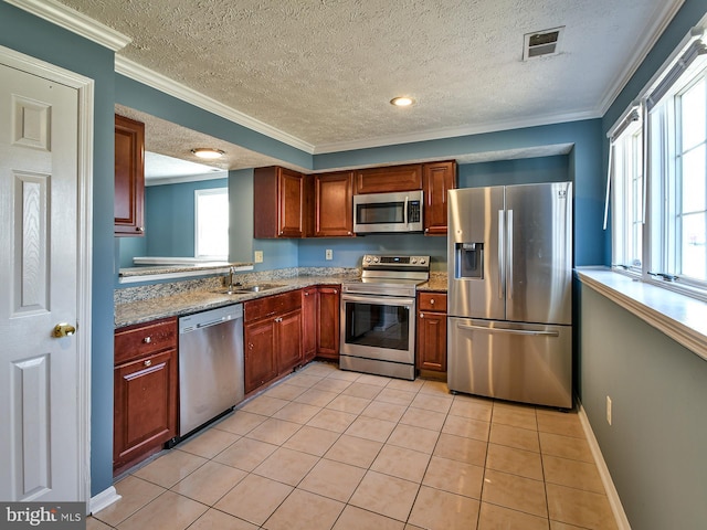 kitchen featuring light tile patterned floors, sink, appliances with stainless steel finishes, light stone counters, and ornamental molding