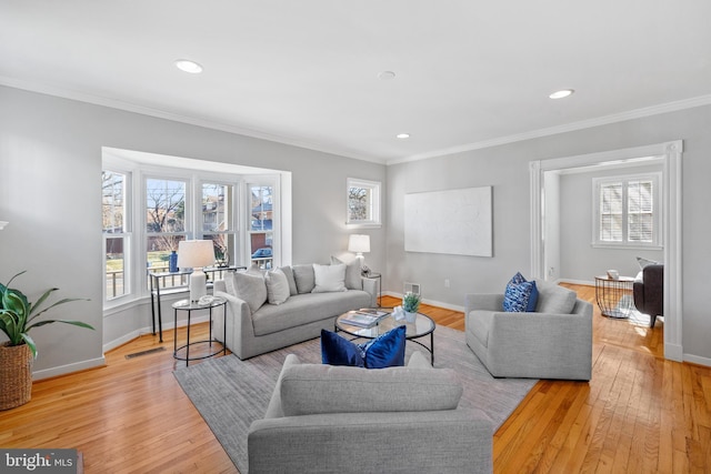 living room with crown molding and light hardwood / wood-style floors