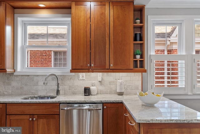 kitchen with tasteful backsplash, sink, light stone countertops, and dishwasher