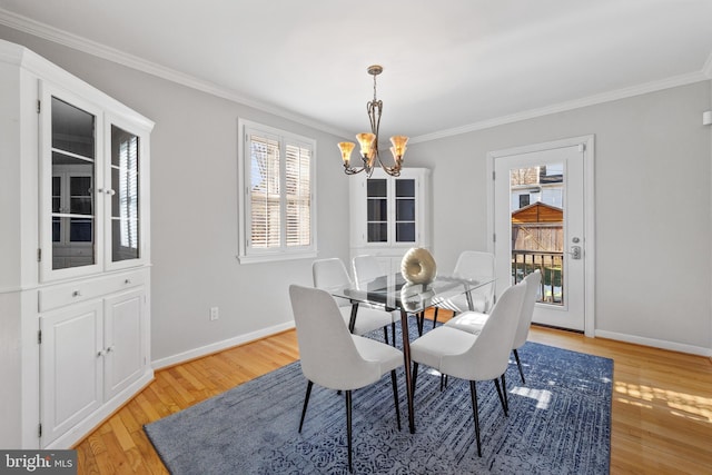 dining room featuring crown molding, a notable chandelier, and light hardwood / wood-style flooring