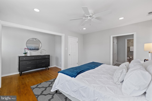 bedroom with connected bathroom, dark wood-type flooring, and ceiling fan