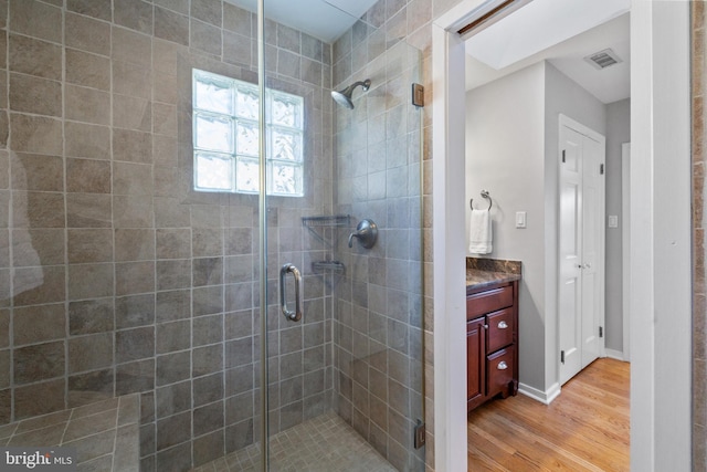 bathroom featuring wood-type flooring, vanity, and walk in shower