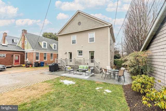 back of house with a patio, outdoor lounge area, a yard, and a deck