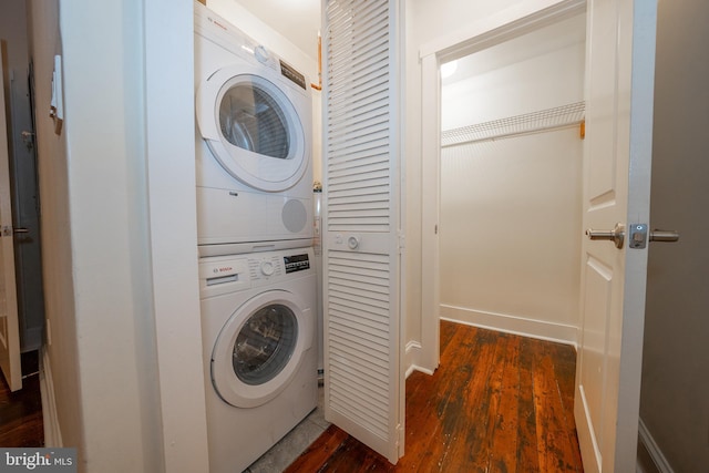 laundry area featuring stacked washer and dryer and dark hardwood / wood-style floors