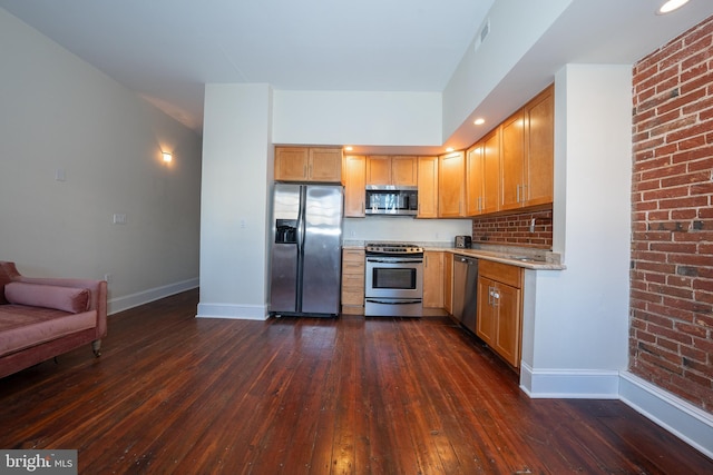 kitchen featuring stainless steel appliances, light stone countertops, and dark hardwood / wood-style flooring