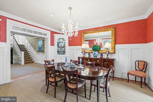 dining space featuring ornamental molding, a notable chandelier, and light hardwood / wood-style flooring