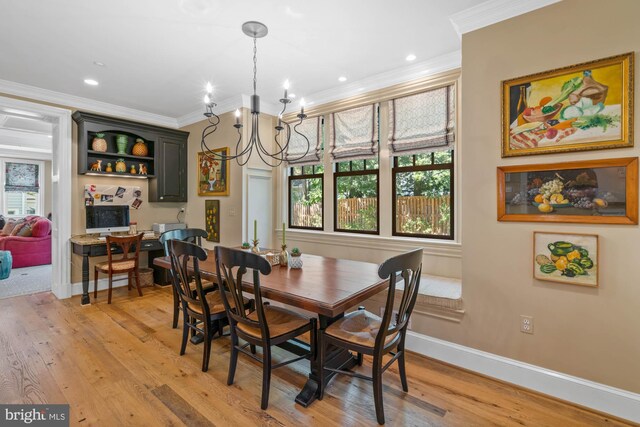 dining space featuring ornamental molding, a chandelier, and light wood-type flooring