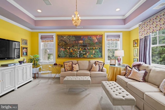 carpeted living room with ornamental molding, a healthy amount of sunlight, a tray ceiling, and a chandelier