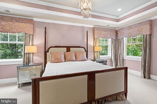 bedroom featuring crown molding, light colored carpet, and a tray ceiling