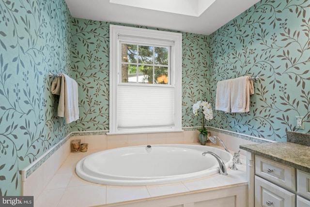 bathroom featuring vanity, a bathtub, and a skylight