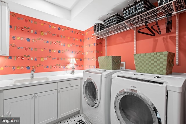 washroom with sink, cabinets, and independent washer and dryer