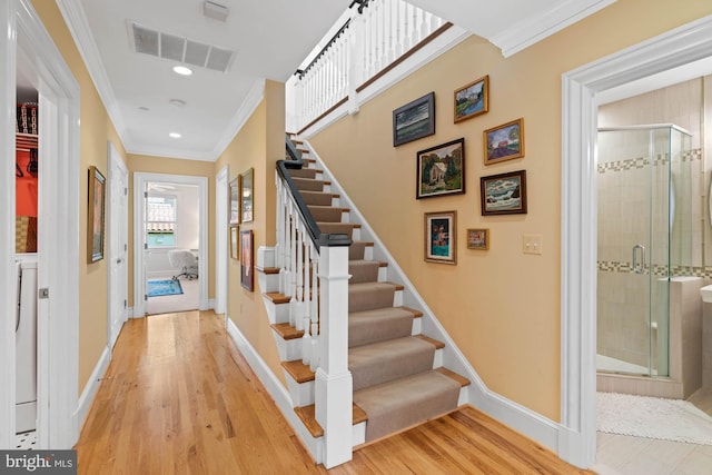 stairs featuring ornamental molding and hardwood / wood-style floors