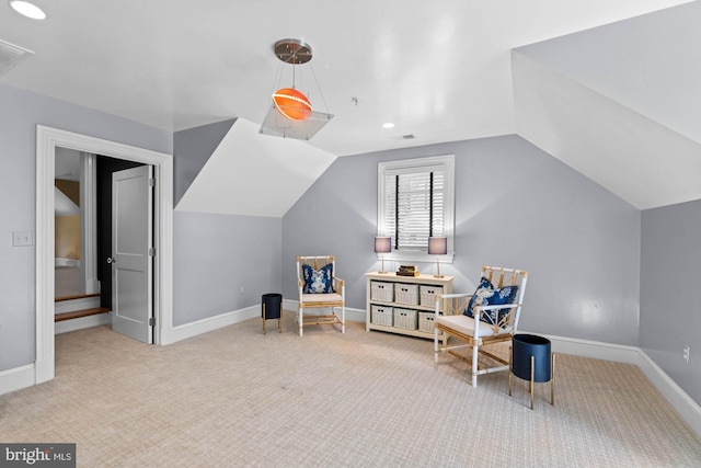 living area featuring lofted ceiling and carpet