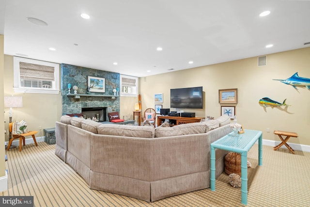 living room featuring a stone fireplace and light carpet