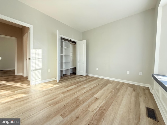 unfurnished bedroom with light hardwood / wood-style flooring and a closet