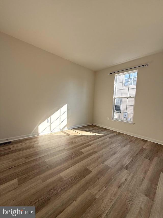 unfurnished room with hardwood / wood-style flooring