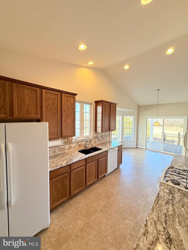 kitchen with lofted ceiling, sink, backsplash, hanging light fixtures, and white appliances