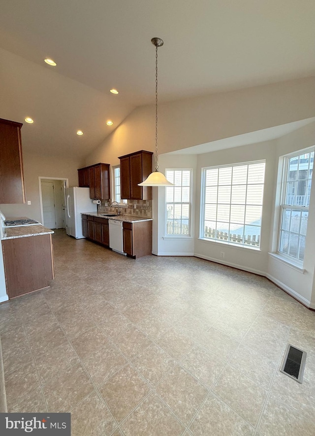 kitchen with vaulted ceiling, pendant lighting, a wealth of natural light, sink, and white appliances