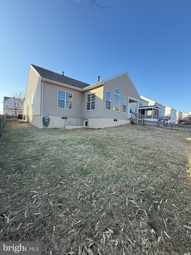 rear view of house featuring a lawn