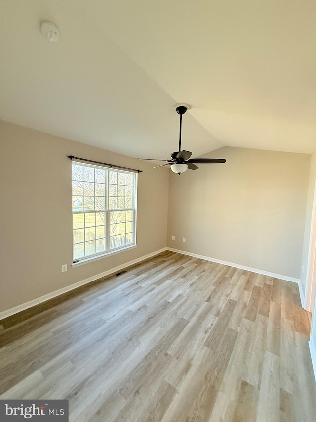 spare room featuring lofted ceiling, light hardwood / wood-style floors, and ceiling fan