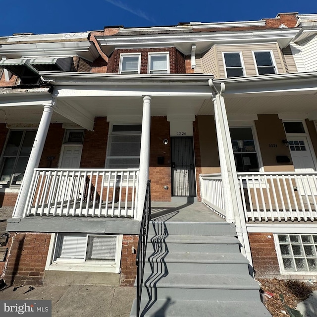 townhome / multi-family property featuring covered porch