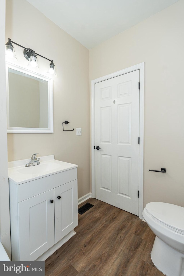 bathroom with vanity, hardwood / wood-style floors, and toilet