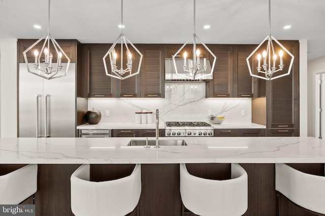 kitchen featuring an inviting chandelier, decorative light fixtures, light stone counters, and decorative backsplash