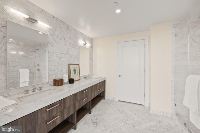 bathroom with vanity, a shower with shower door, and tile walls