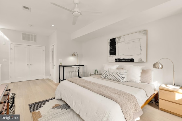 bedroom featuring ceiling fan, light hardwood / wood-style floors, and a closet