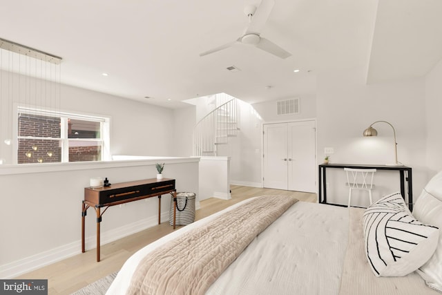 bedroom with ceiling fan, light hardwood / wood-style floors, and a closet