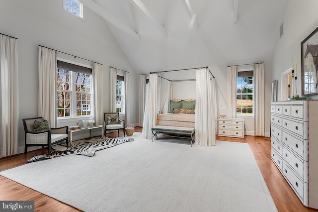 sitting room featuring beam ceiling, high vaulted ceiling, and light wood-type flooring