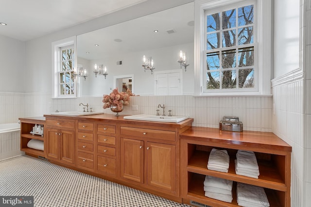 bathroom with vanity, tiled bath, and tile walls