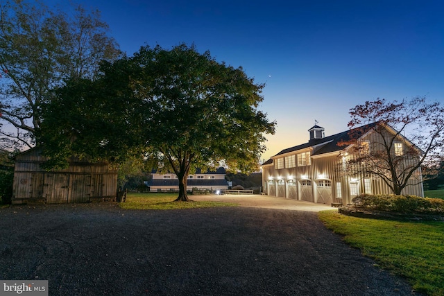 yard at dusk featuring a garage