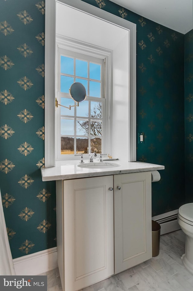 bathroom featuring a baseboard radiator, sink, and toilet