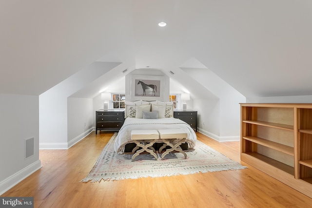 bedroom with hardwood / wood-style flooring and lofted ceiling