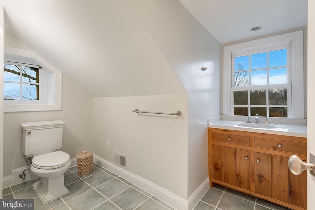 bathroom with vaulted ceiling, vanity, tile patterned floors, and toilet