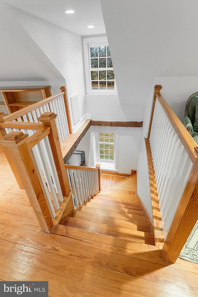 staircase featuring plenty of natural light and hardwood / wood-style floors