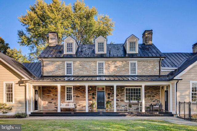 rear view of house featuring a porch and a yard