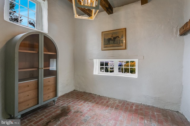 unfurnished dining area featuring beam ceiling